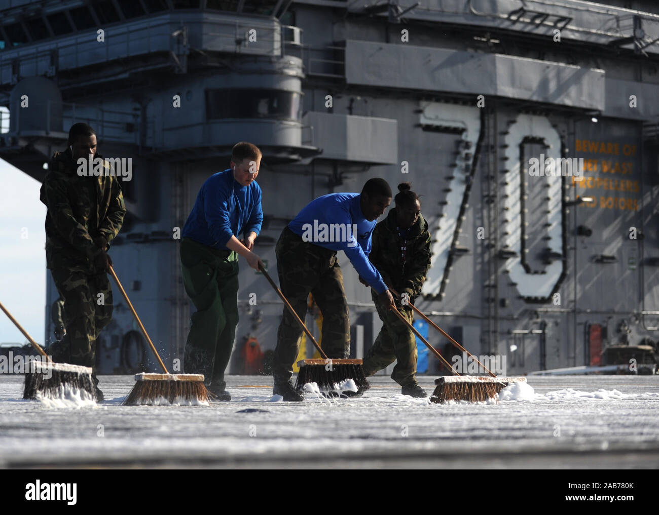 PACIFIC OCEAN (Feb. 3, 2013) Sailors participate in a fight deck scrubbing exercise aboard the aircraft carrier USS Carl Vinson (CVN 70). Carl Vinson is underway conducting sea trials as the final stage of a six-month planned incremental availability. Stock Photo