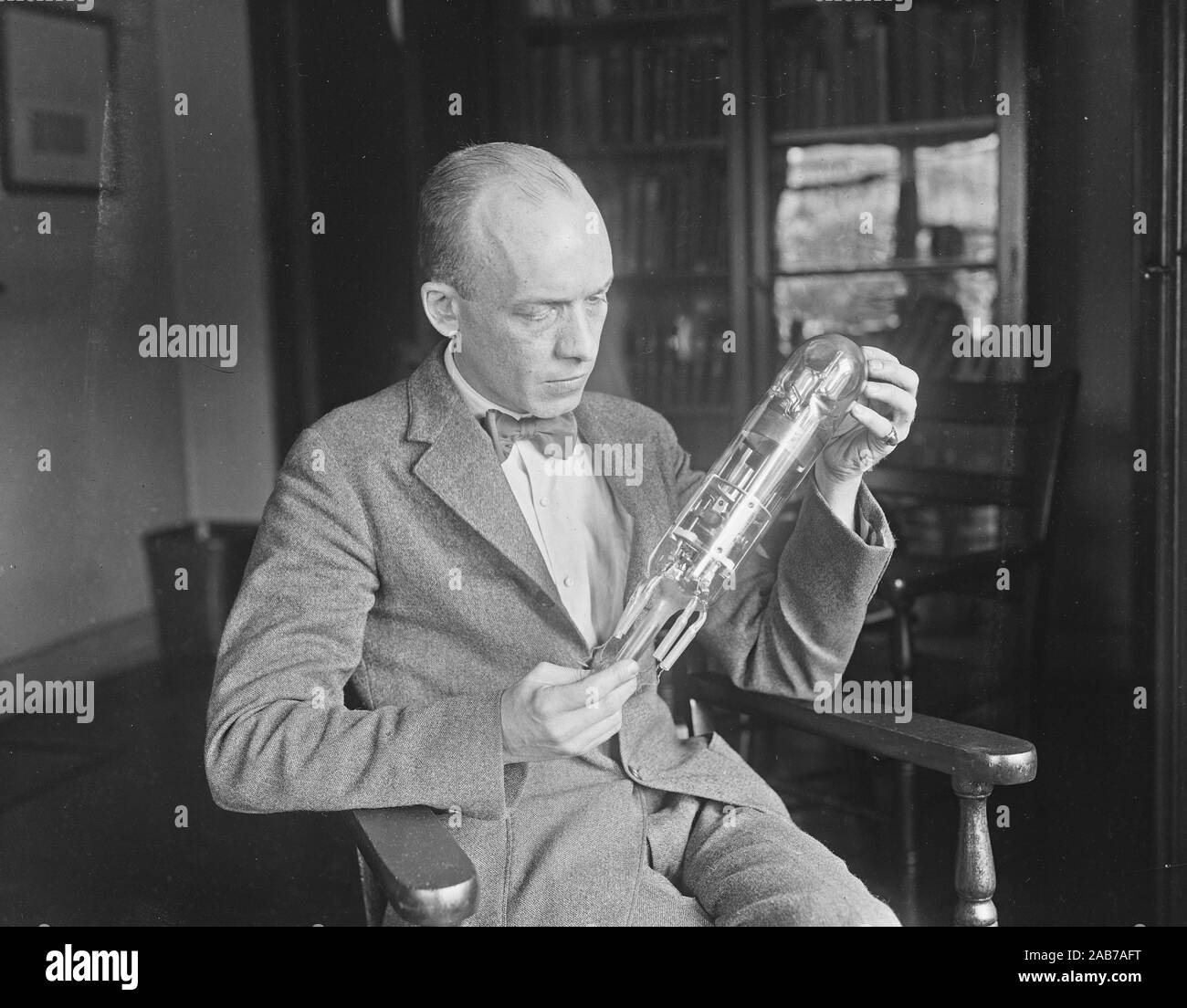 First radio vacuum tube. Carl W. Mitman, Curator of Engineering, US Nat'l Museum, holding what is believed to be the 1st radio tube. It was made in 1898 by D. Mefarlan Moore of NY. ca. June 1924 Stock Photo