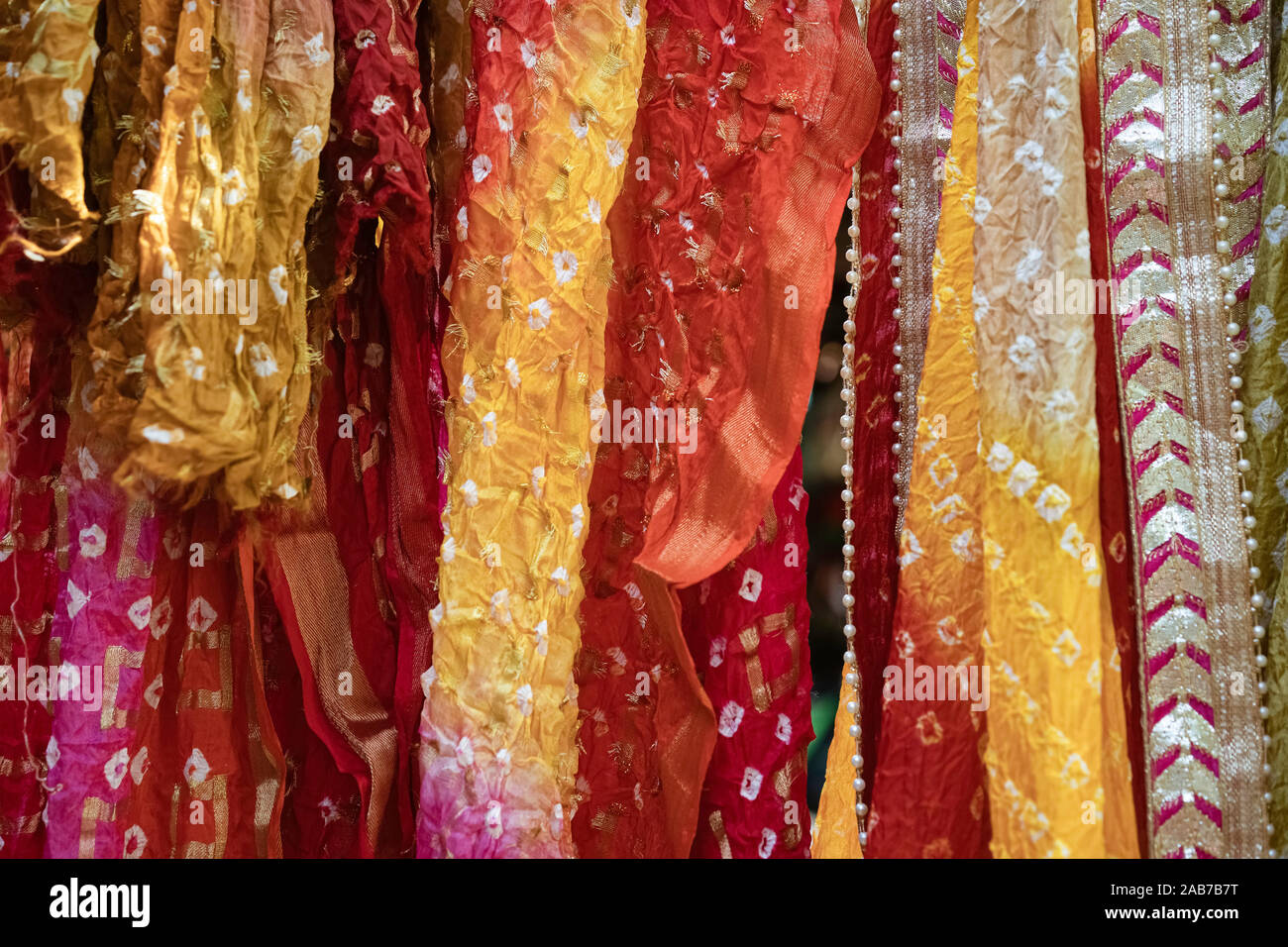 Delhi, Uttar Pradesh, India. Colourful saris and shawls (dupatta) hang in a street display of indigenous handiwork in Dilli Haat, Delhi, India. Stock Photo