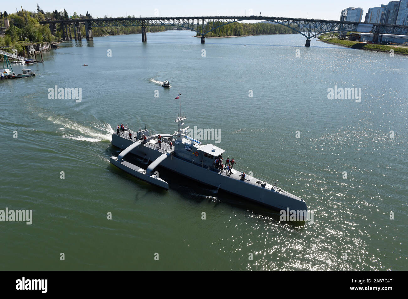 PORTLAND, Ore. (Apr. 7, 2016) Sea Hunter, an entirely new class of unmanned ocean-going vessel gets underway on the Williammette River following a christening ceremony in Portland, Ore. Part the of the Defense Advanced Research Projects Agency (DARPA)'s Anti-Submarine Warfare Continuous Trail Unmanned Vessel (ACTUV) program, in conjunction with the Office of Naval Research (ONR), is working to fully test the capabilities of the vessel and several innovative payloads, with the goal of transitioning the technology to Navy operational use once fully proven. Stock Photo