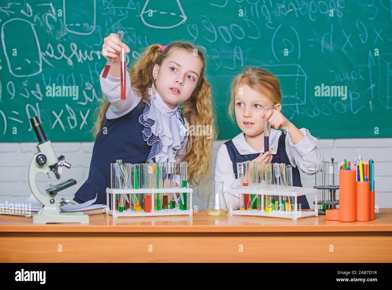 We love science. School children performing experiment in science ...