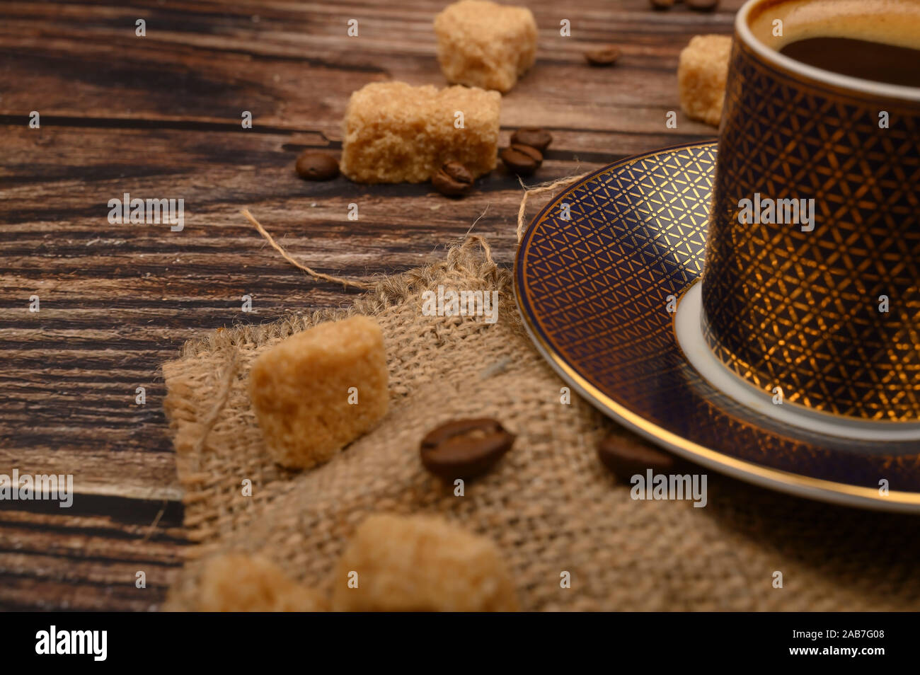 Coffee Cup, brown sugar and coffee beans on wooden background. Close up Stock Photo
