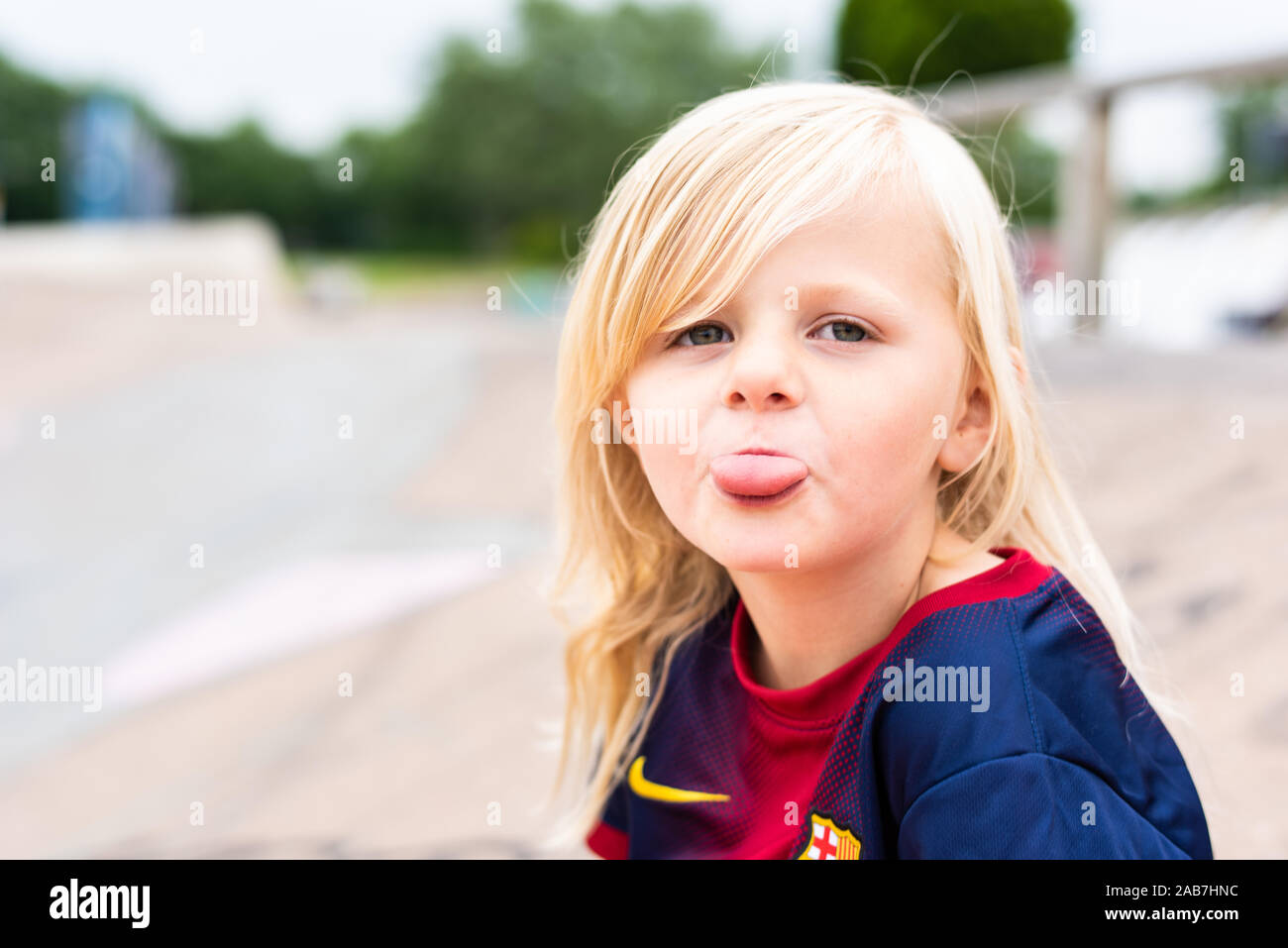 A Cute Pretty Little Blonde Haired Girl Wearing A Football Shirt