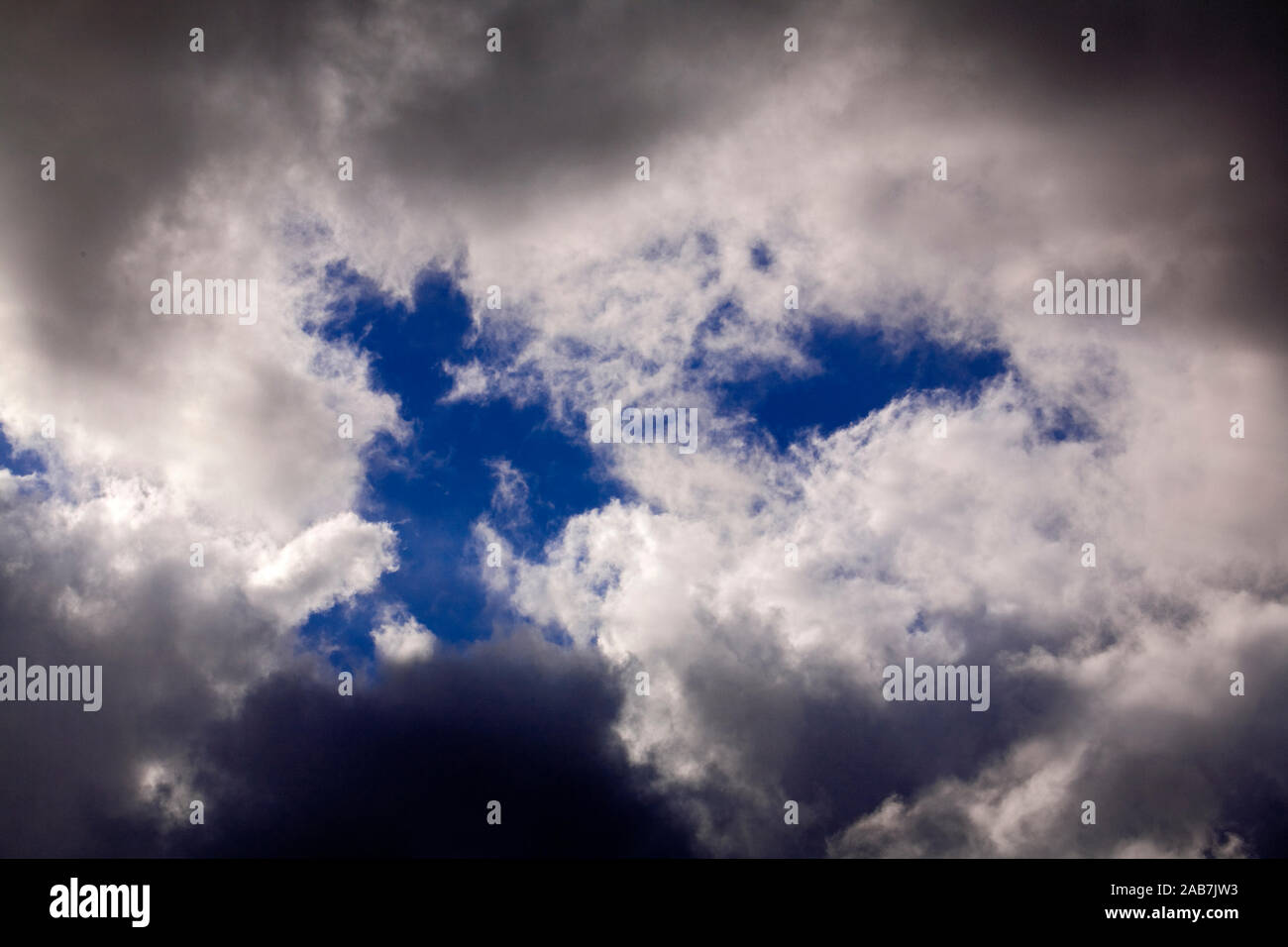 Dunkle Regenwolken und und Wolkenschleier schieben sich vor die Sonne Stock Photo