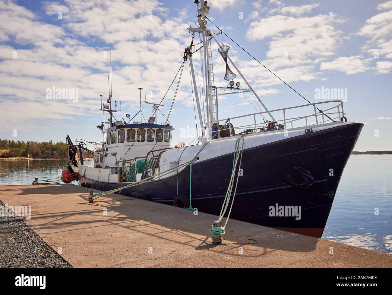 Big fishing ship anchored on the dock on a sunny summer day at the Kasnäs, Kemiö Island in Finland Stock Photo