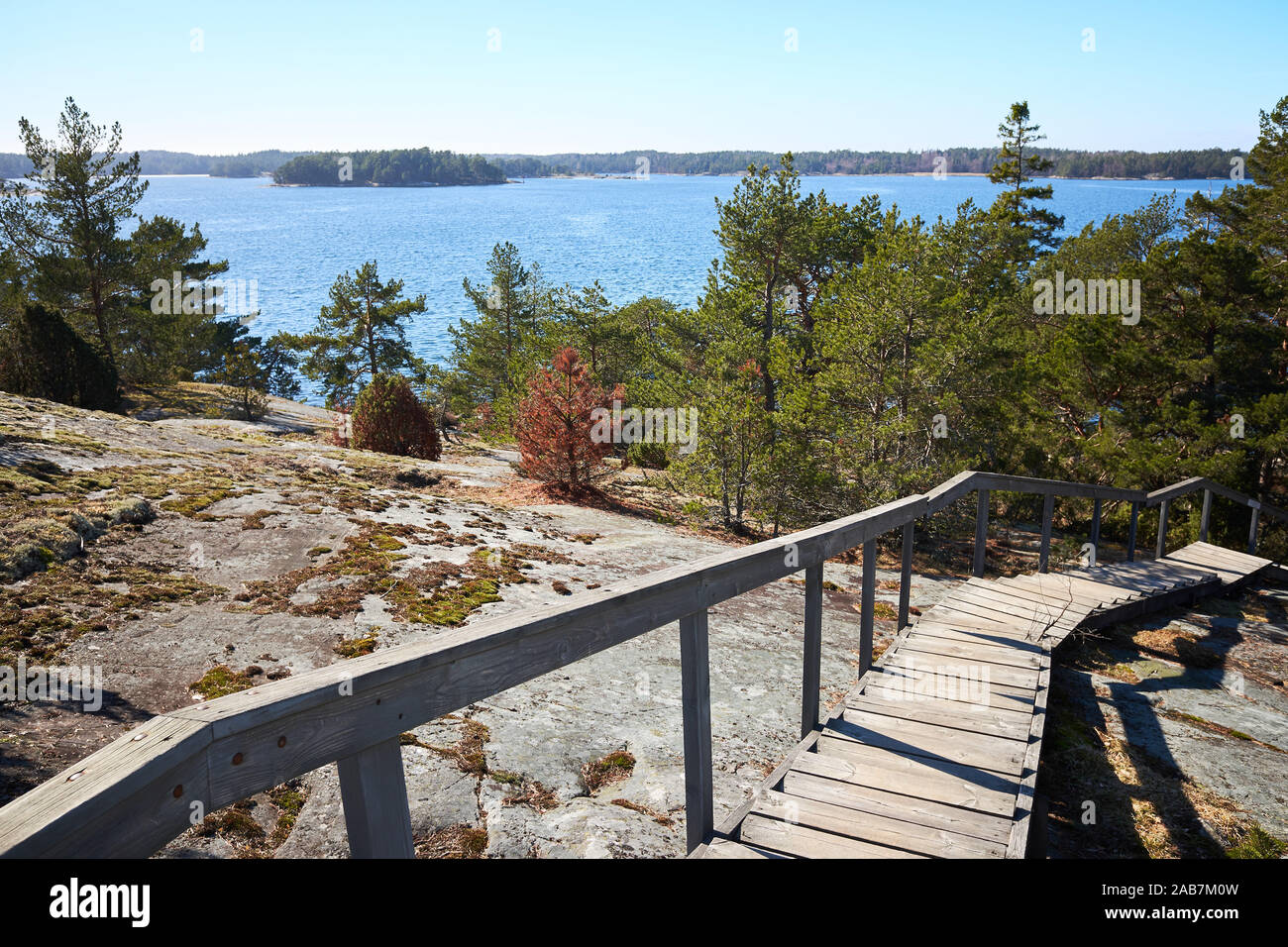 Wooden stairs leading down from the rocks towards the sea. sunny spring day at Finnish archipelago in the Kemiö Island, Finland. Stock Photo