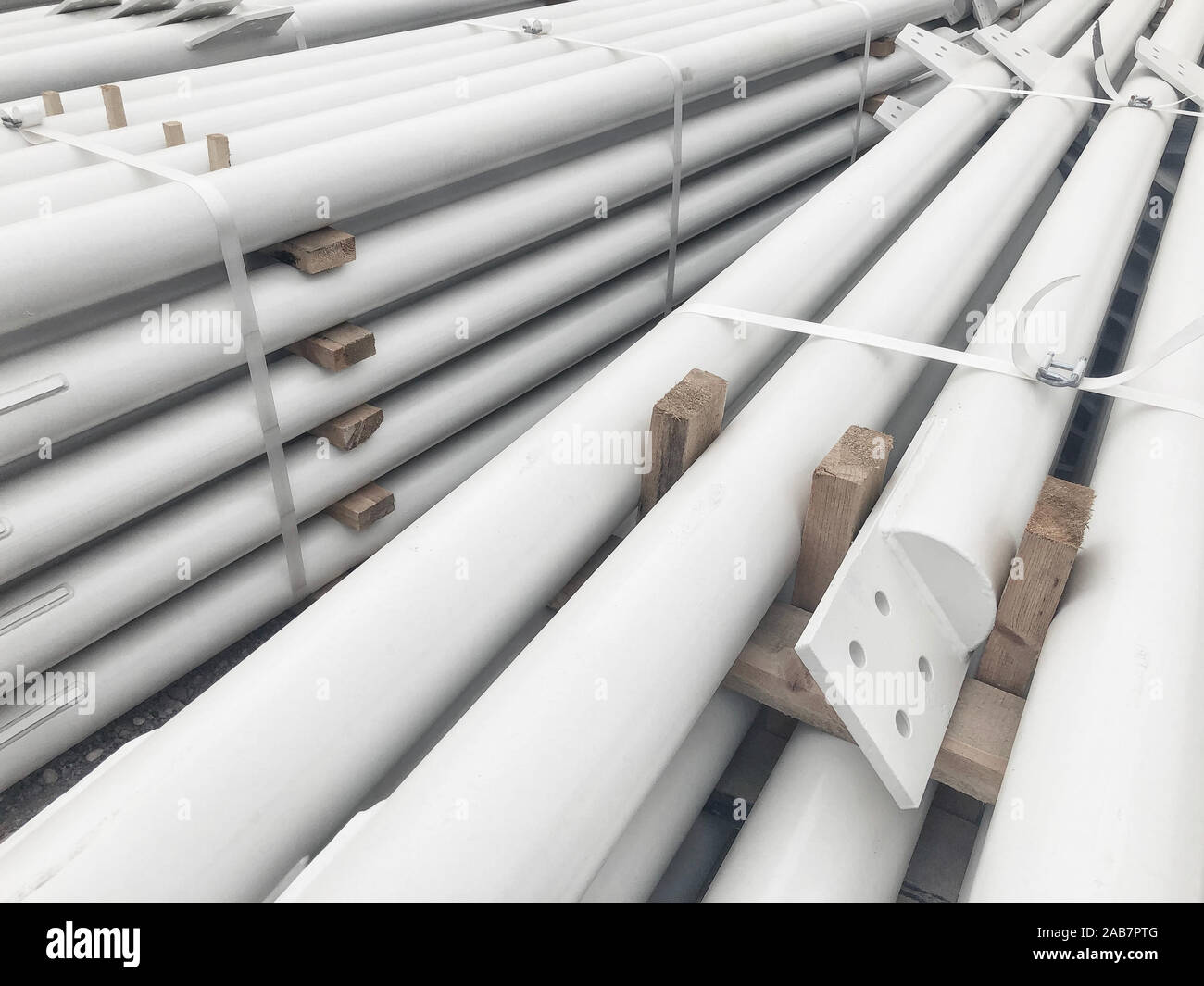 White colored stacked metal diagonal bracings with holes for bolts. Stacked metal parts of a pre-fabricated building. Fast-built camp construction par Stock Photo
