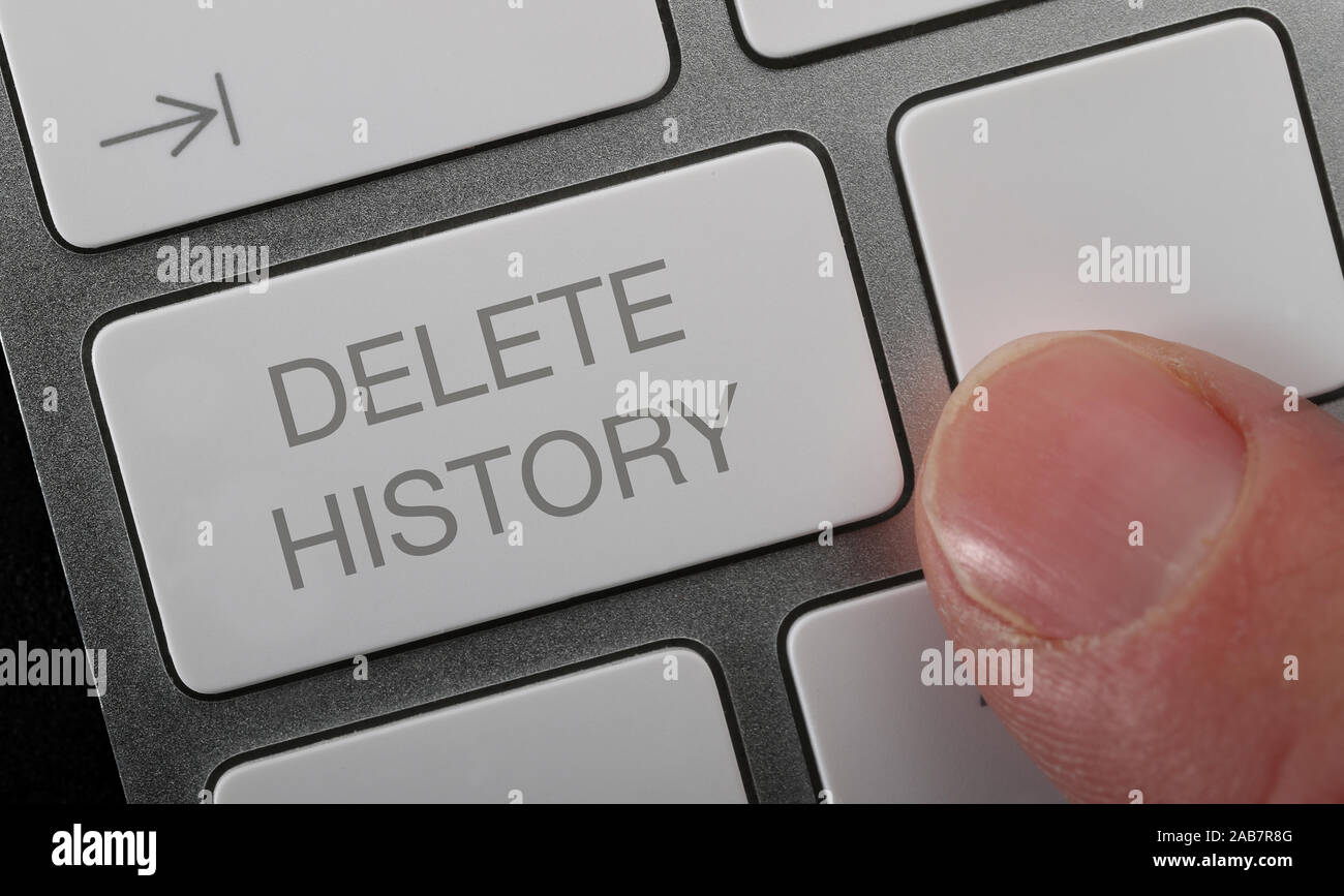 A man pressing a key on a computer keyboard with the words delete history. Stock Photo