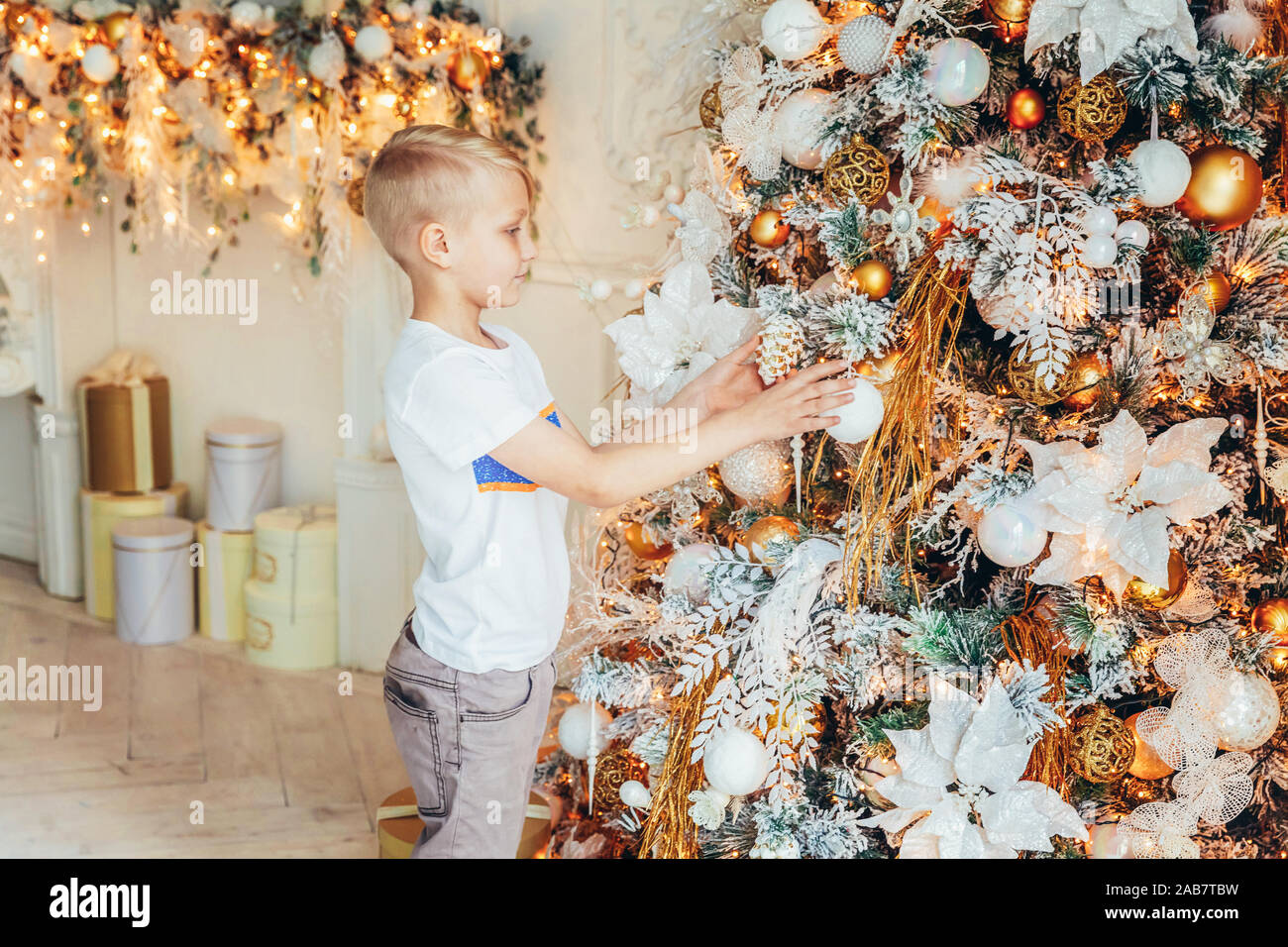 Young Boy Decorating Christmas Tree On Christmas Eve At Home