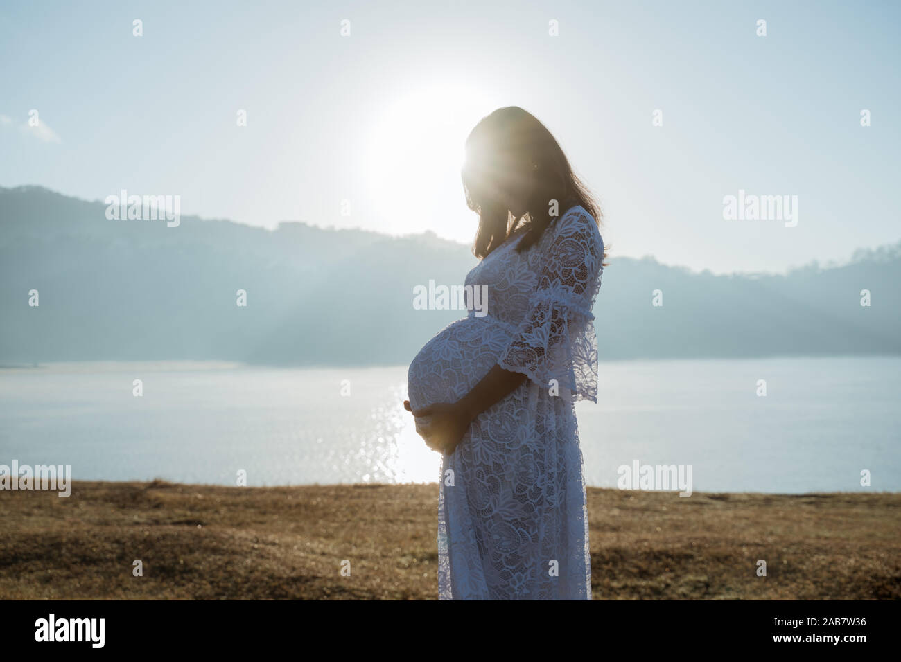 pregnant mother holding her stomach Stock Photo - Alamy