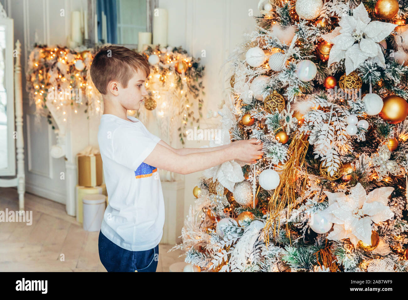 Young Boy Decorating Christmas Tree On Christmas Eve At Home