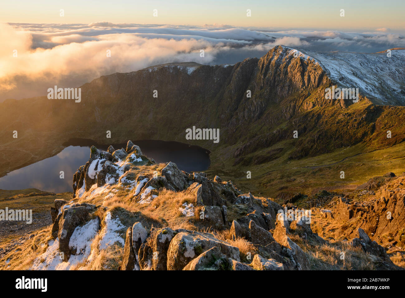 Morning light illuminates the top of Craig Cau during a cloud inversion, photographed from the top of Cadair Idris, Snowdonia, Wales, United Kingdom Stock Photo