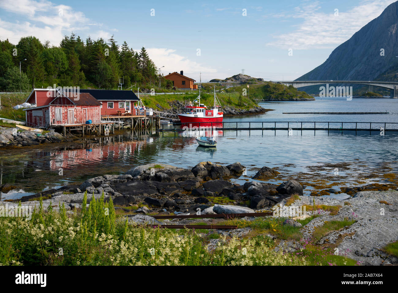 A fishing boat and dock houses near Kakern Bridge, Ramberg, Lofoten Islands, Norway, Europe Stock Photo