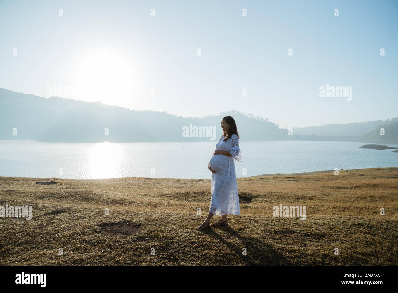 pregnant mother holding her stomach Stock Photo - Alamy