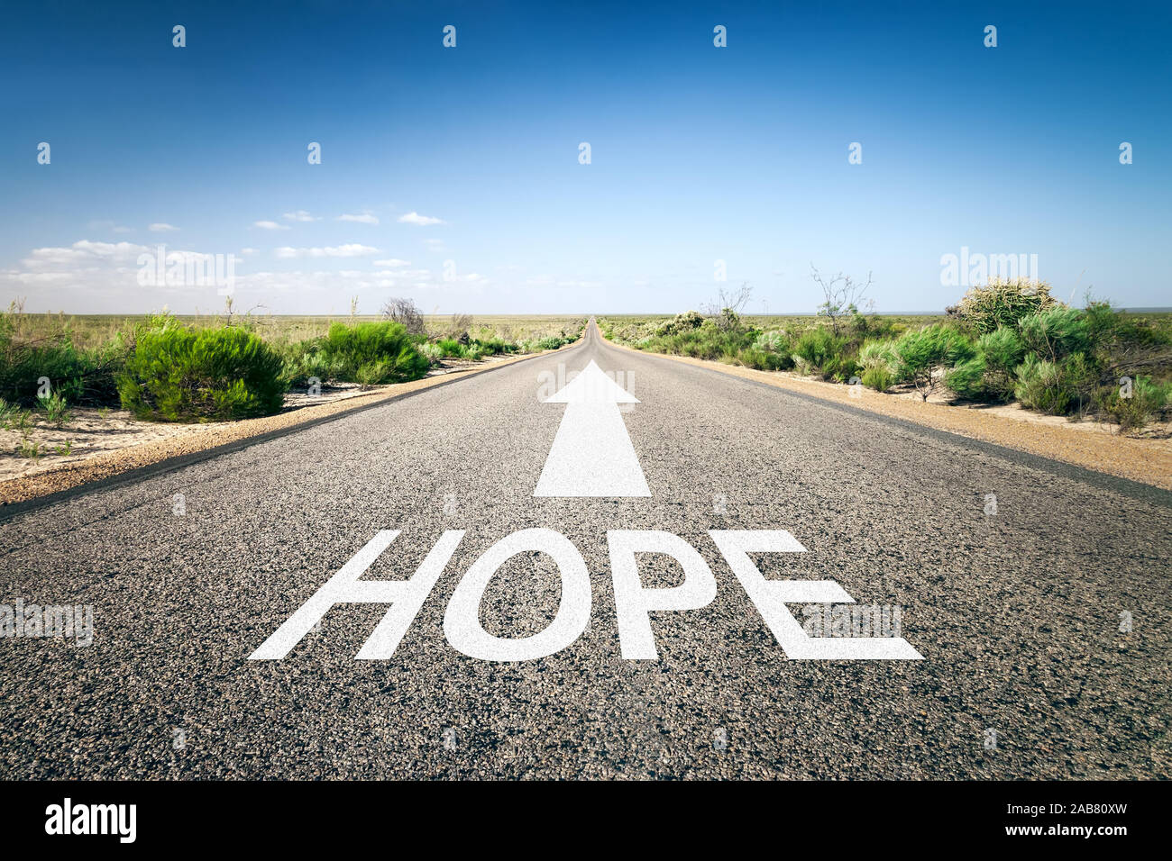 Eine unendlich lange Strasse mit der wegweisenden Aufschrift: 'Hope' Stock Photo