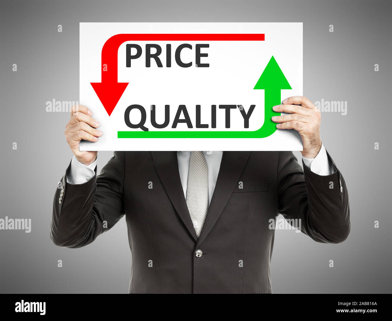 Ein Geschaeftsmann, der ein Schild mit den Worten 'Price Quality' haelt Stock Photo