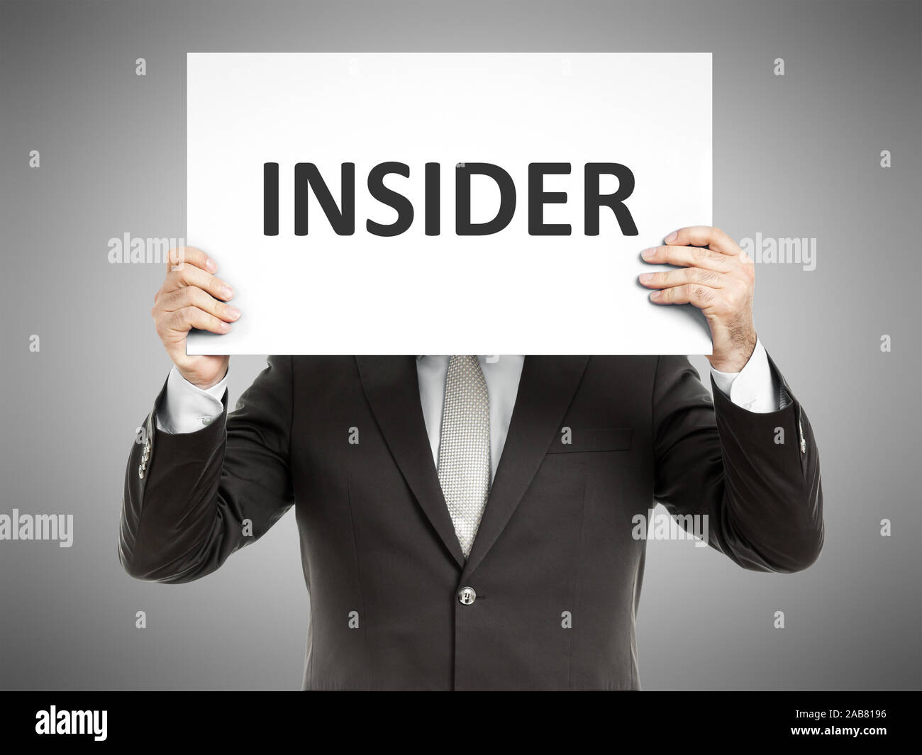 Ein Geschaeftsmann, der ein Schild mit den Worten 'Insider' in der Hand haelt Stock Photo