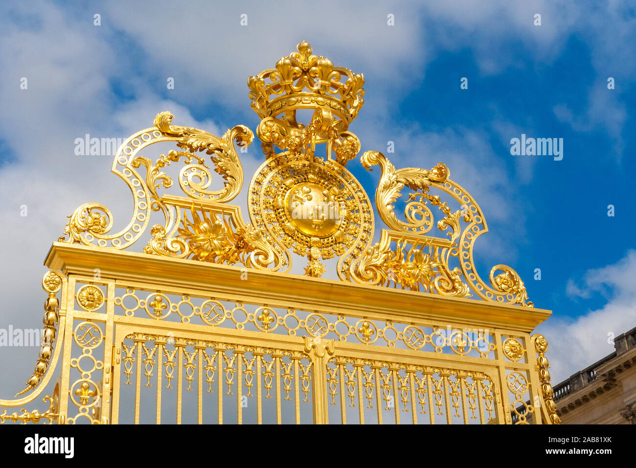 Perfect close-up view of the shiny golden Royal Gate, an elaborate gold leaf gate, seen from the Cour d'Honneur at the famous Palace of Versailles on... Stock Photo