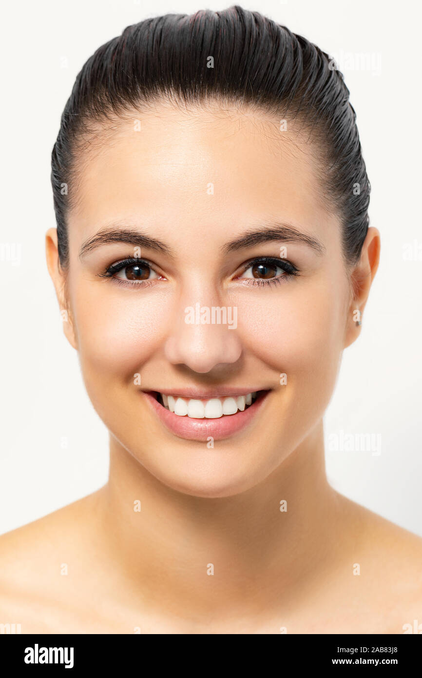 Close up beauty portrait of young attractive woman with healthy skin. Girl with charming smile isolated on white background. Stock Photo