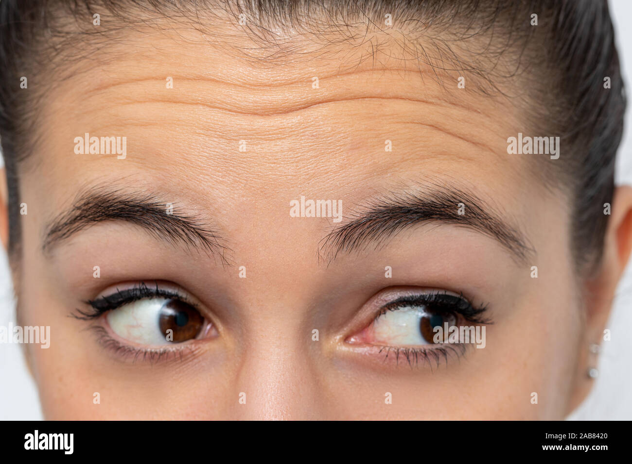 Close up detail of woman looking aside frowning forehead. Prominent wrinkles shown on skin. Stock Photo