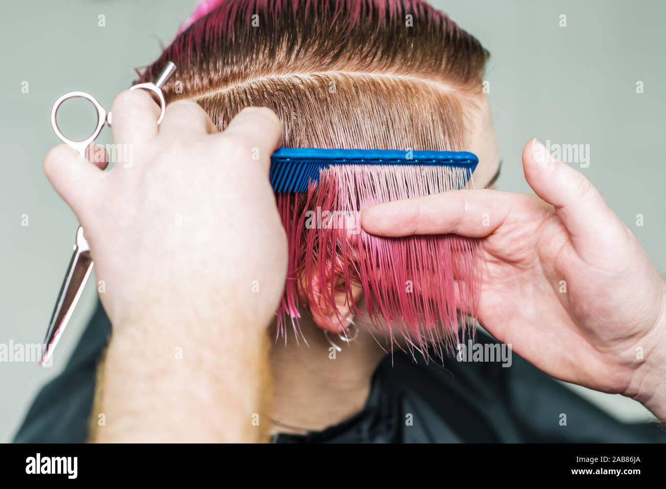 Hands Of Professional Hairdresser Combing Pink Short Hair Close Up