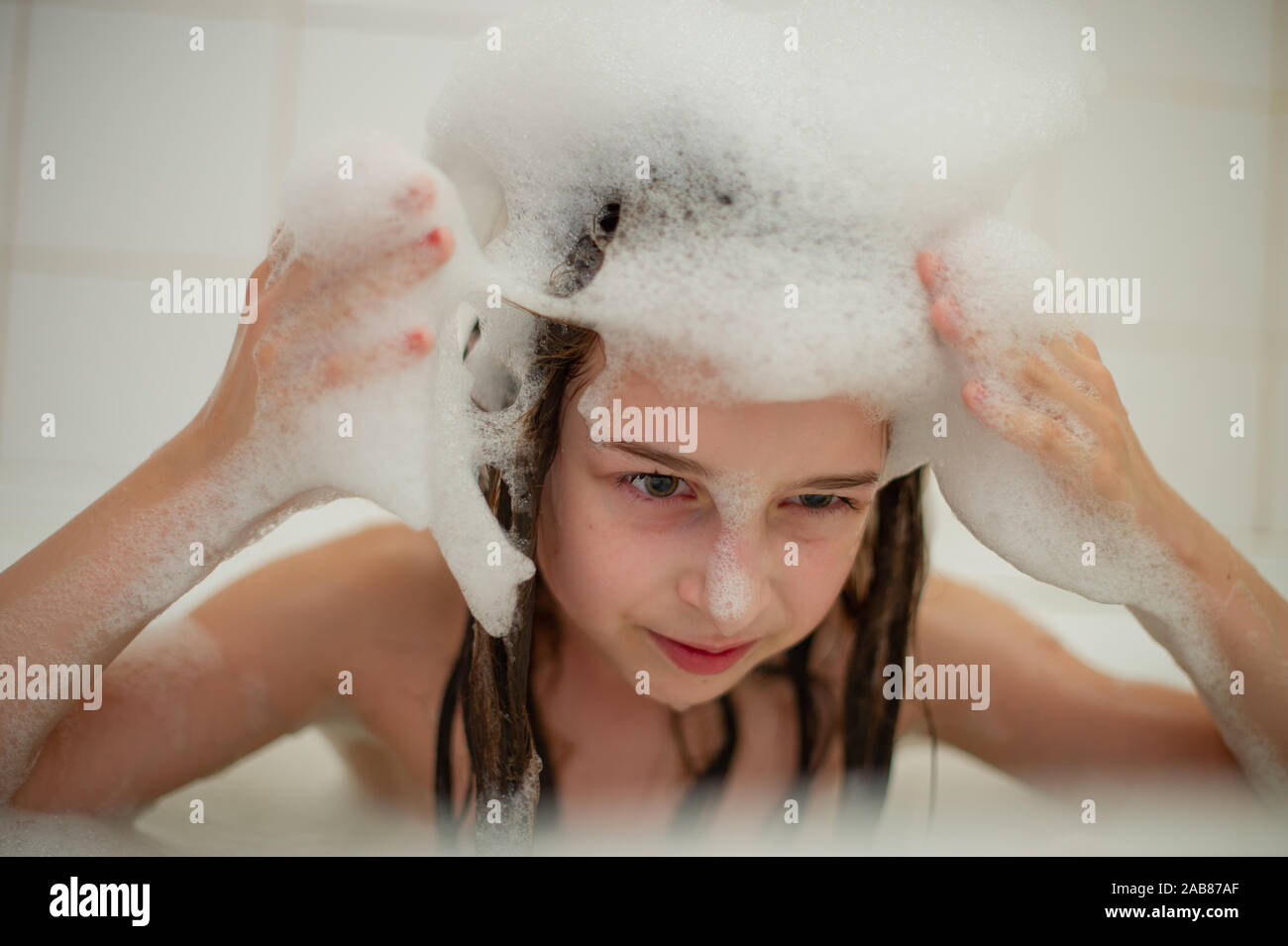 Young girl inside the bath. A little girl bathes in a bathtub with foam