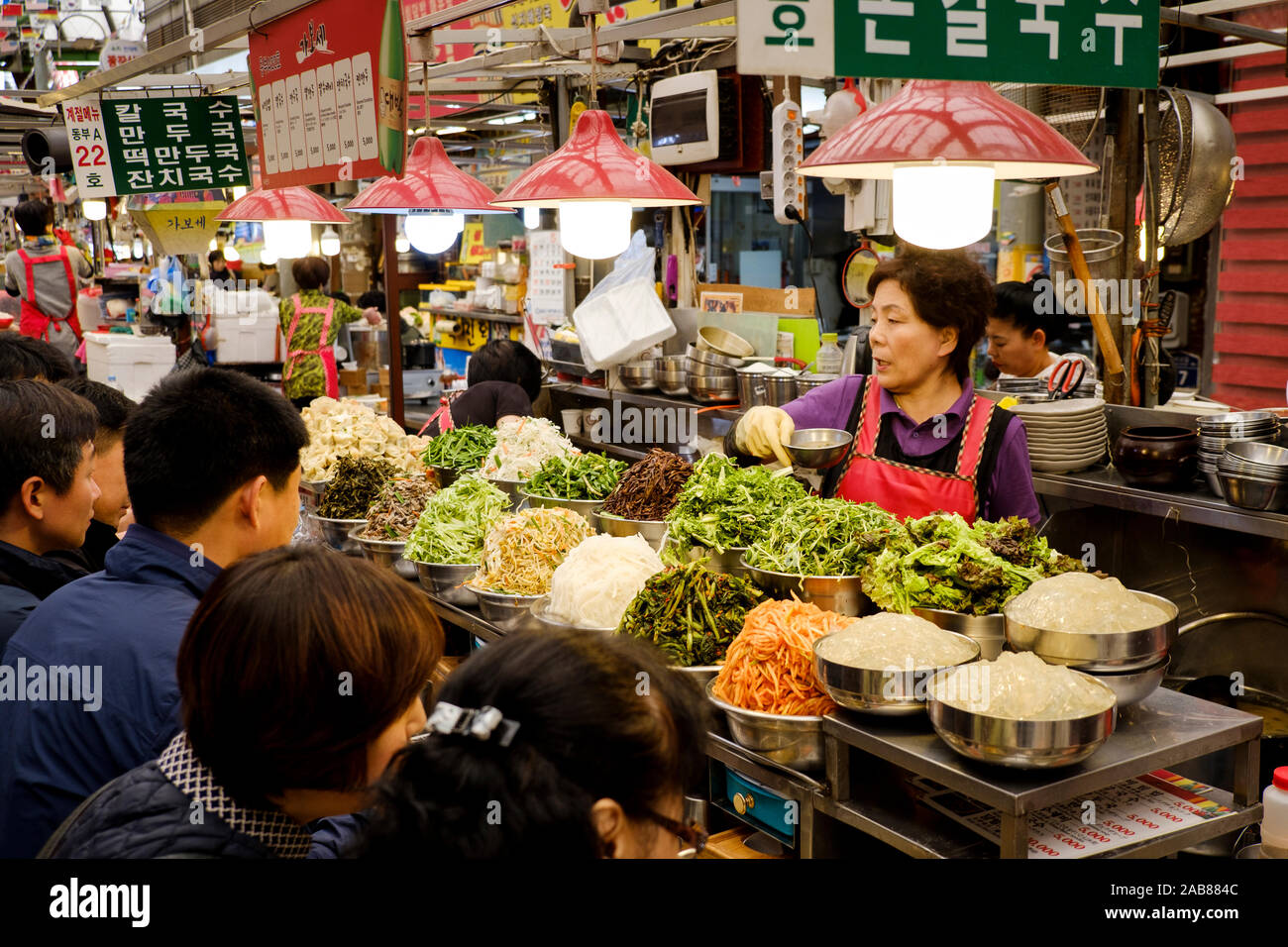 Customers at a Korean street food stall at Gwangjang Market (or Kwangjang Mkt.), Jongno-gu, Seoul, South Korea. Stock Photo