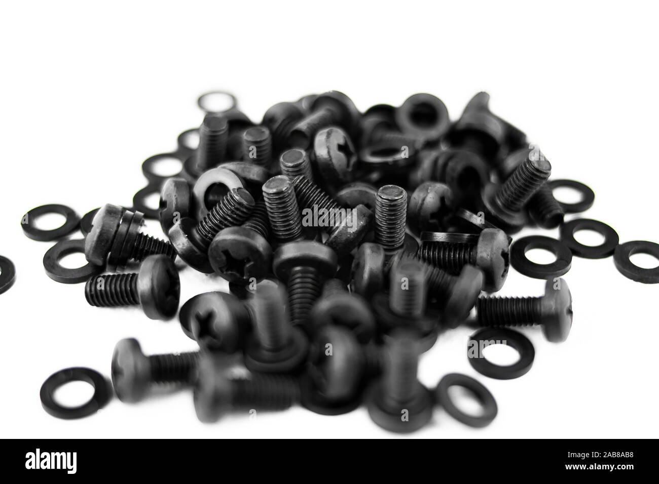 Heap of screws and black metal washers on white background Stock Photo