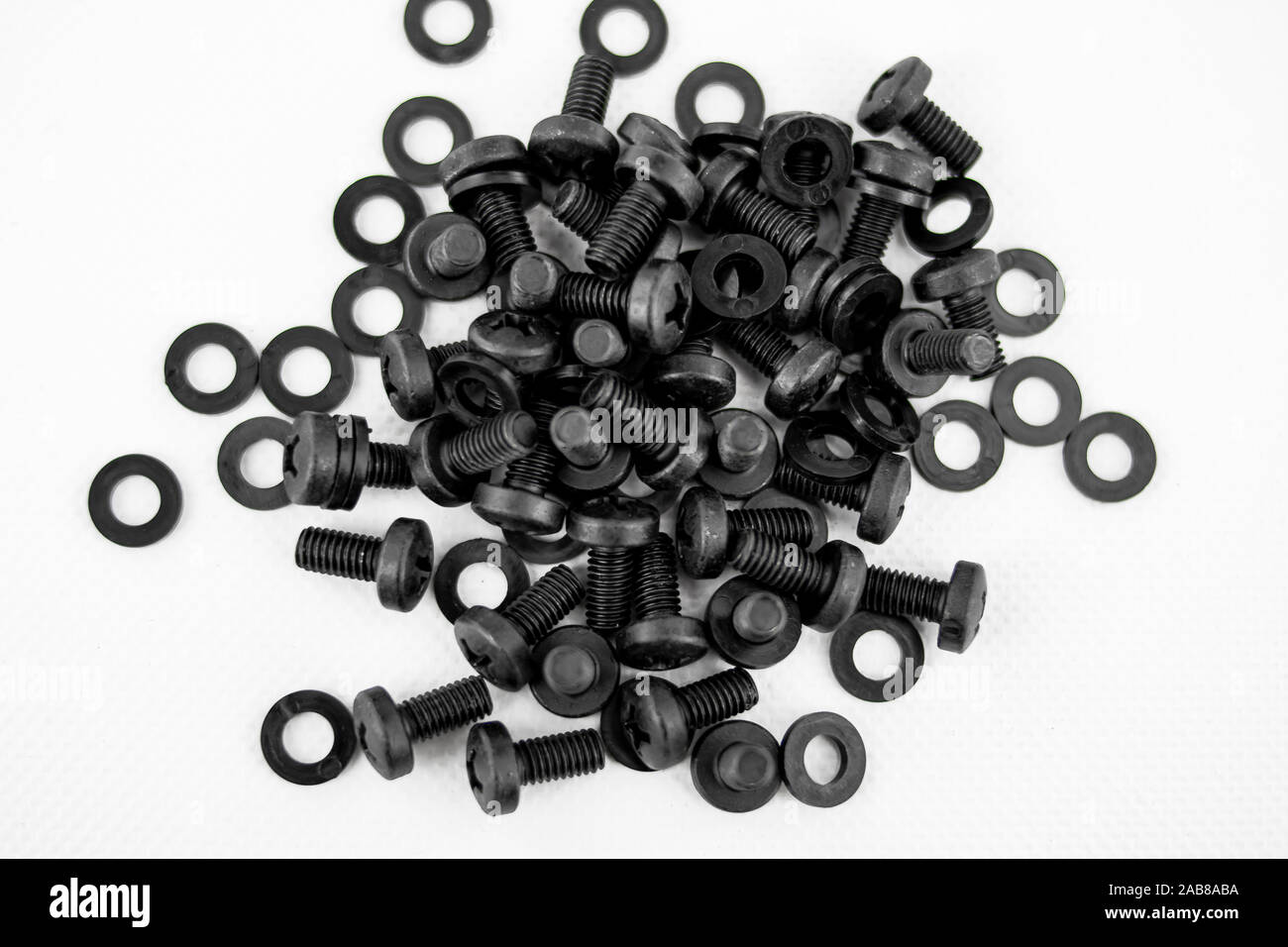 Screws and black washers piled on a white background Stock Photo