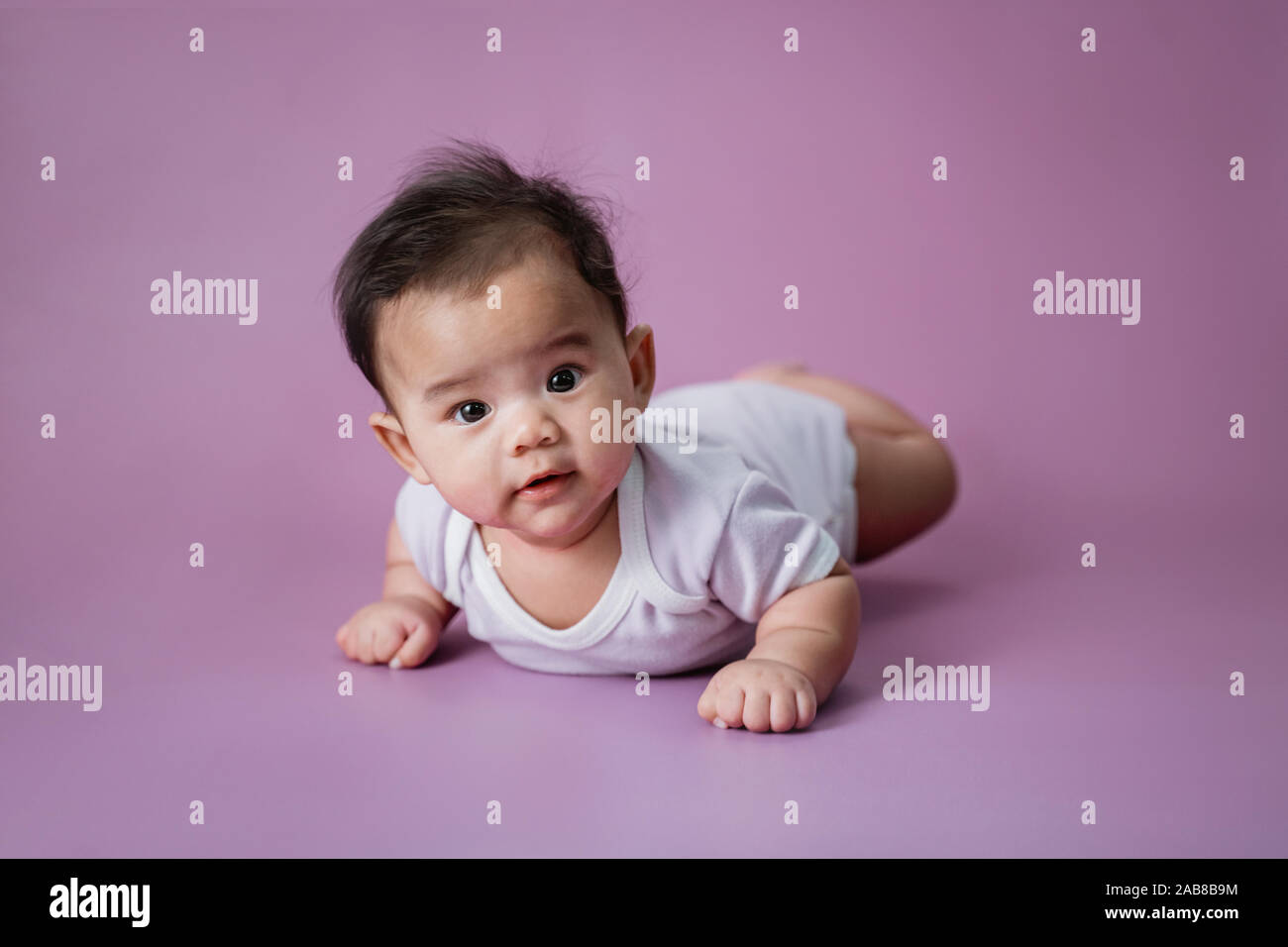 baby laying on her belly in studio Stock Photo Alamy