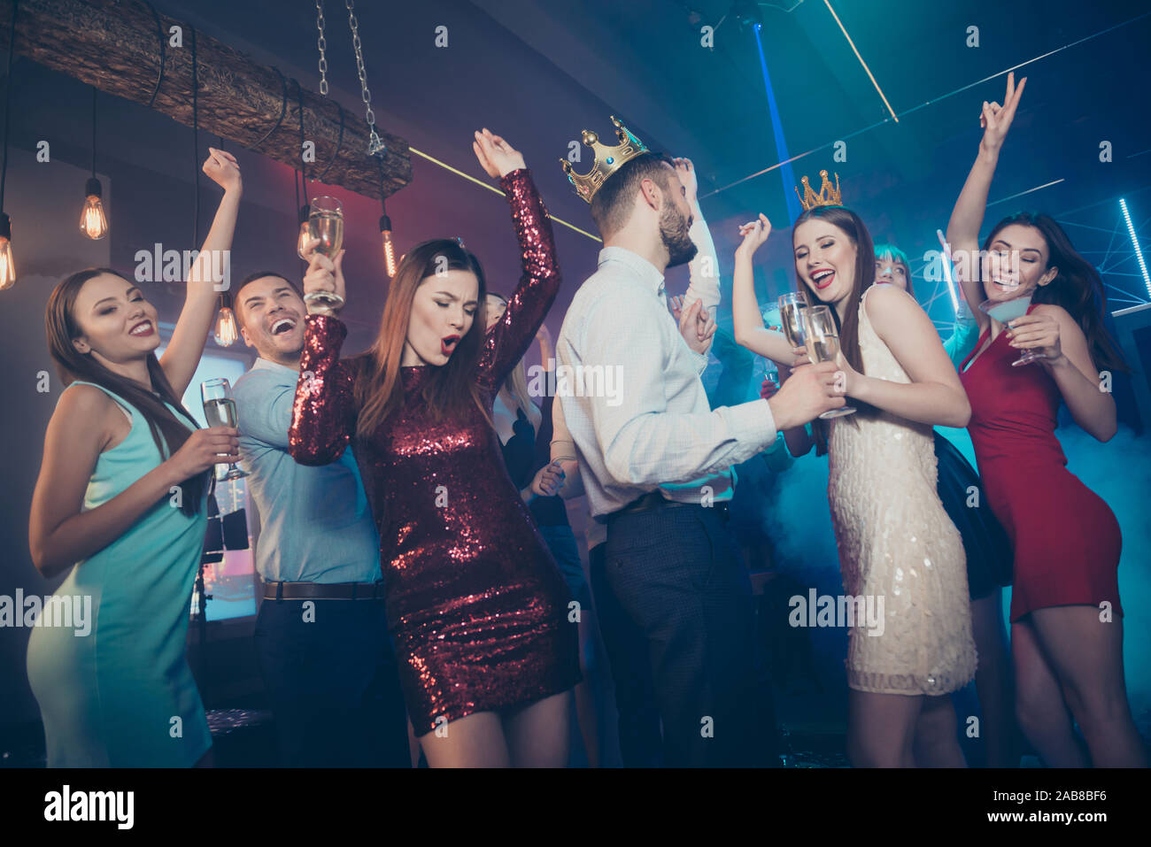 Clink cheers toast for excited prince and princess. Photo of excited cheerful glad carefree buddies celebrating prom with winners drinking alcohol Stock Photo