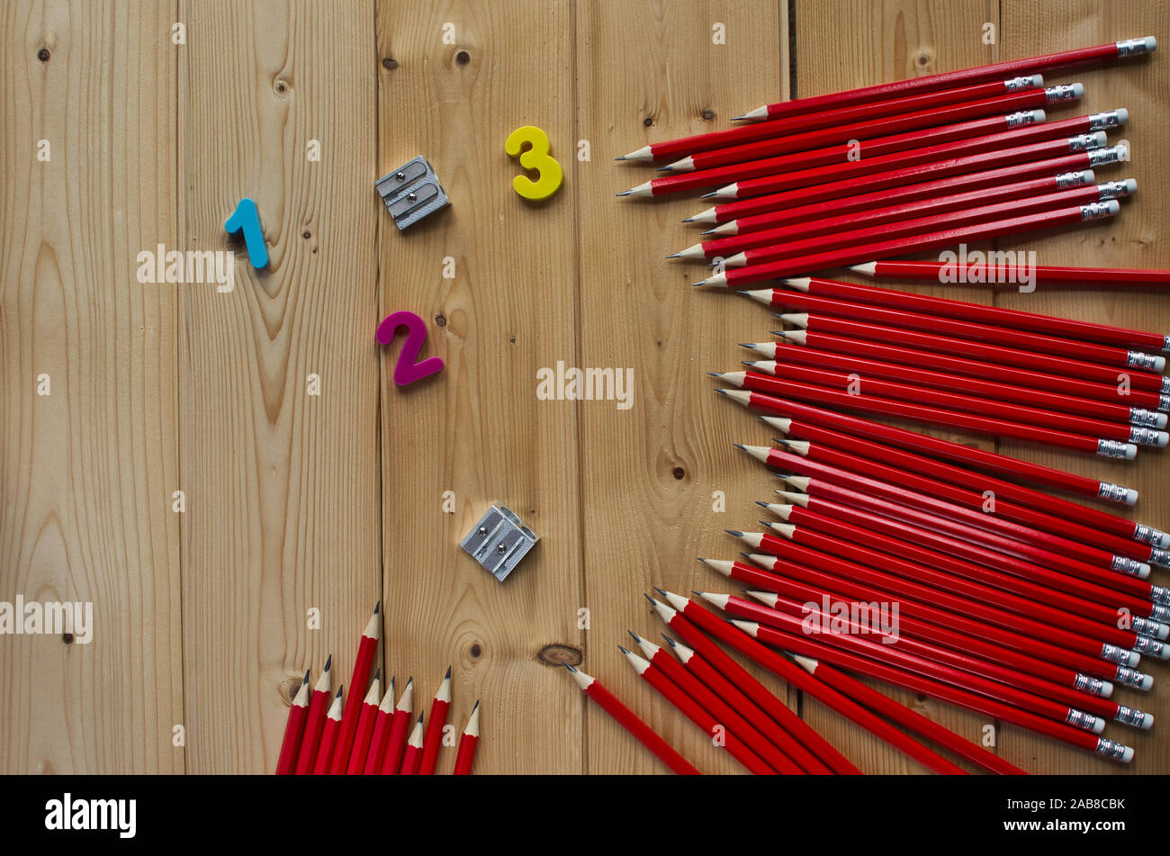 Set of red graphite pencils,colorful numbers and shapeners on wood ...