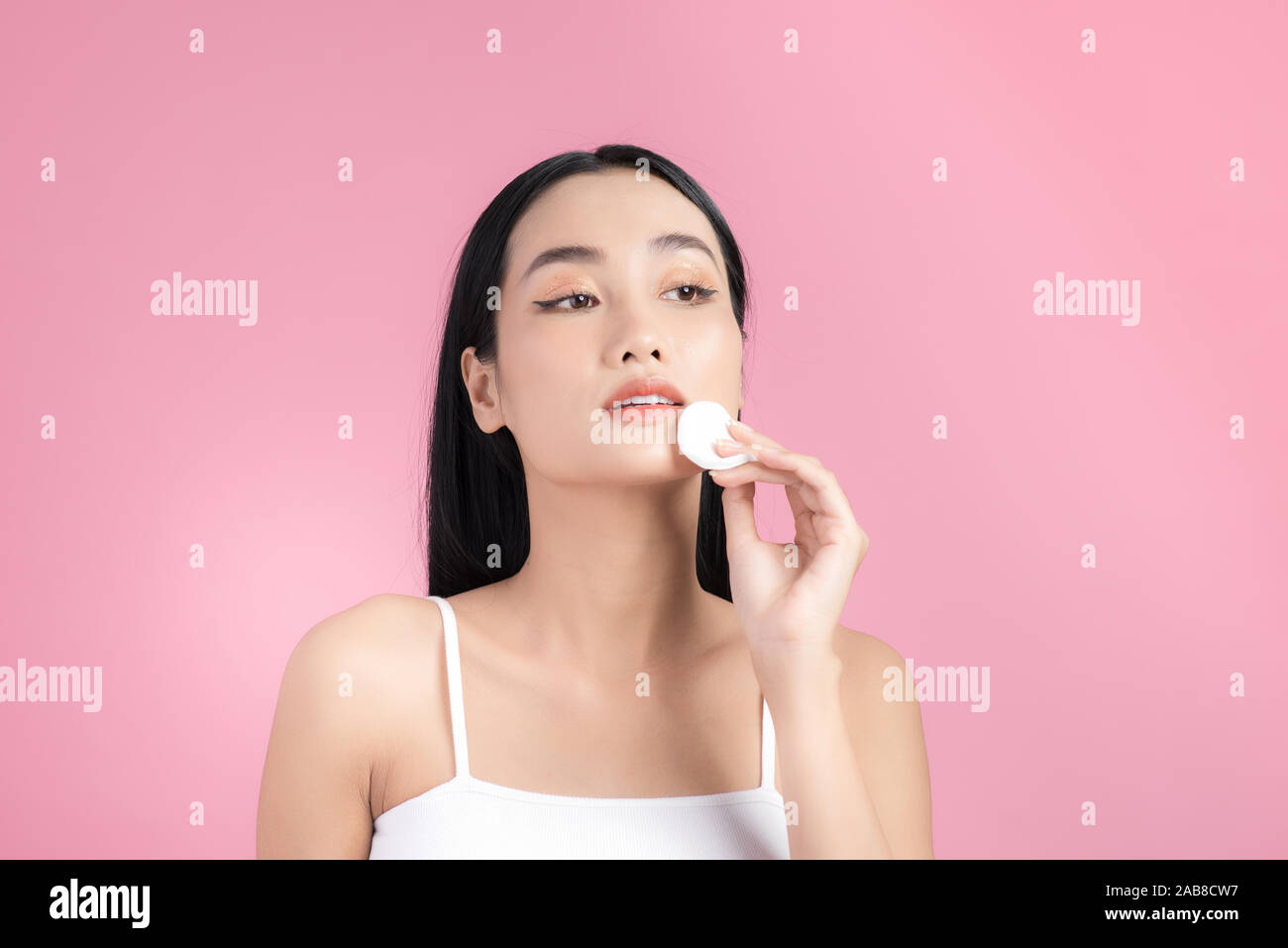 Girl remove makeup. Woman hand with pad. Skin clean with cotton Stock