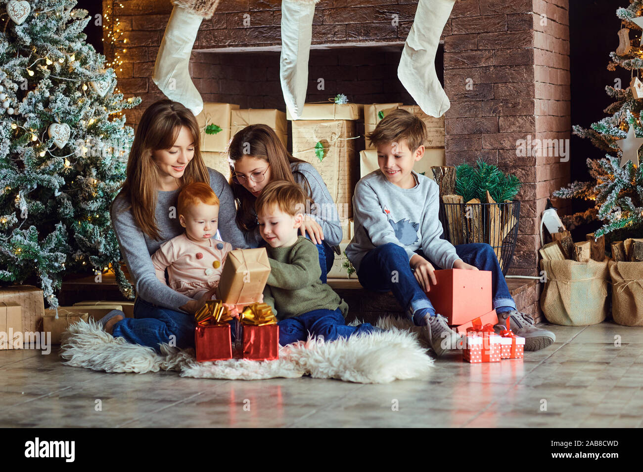 Mother and kids opening Christmas presents Stock Photo