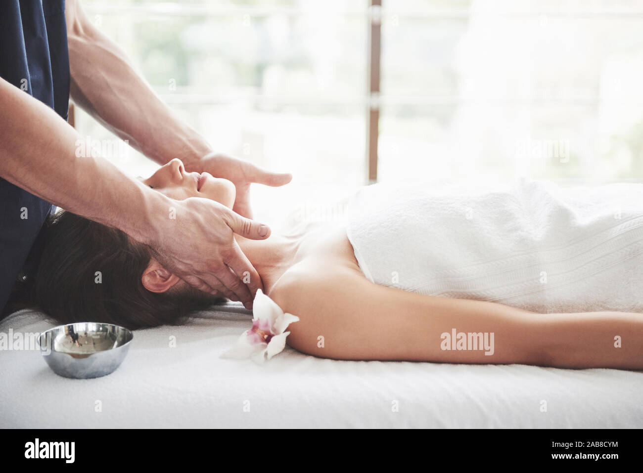 The masseur makes a relaxing massage of the trapezius muscles and back to  the client lying on the couch Stock Photo - Alamy