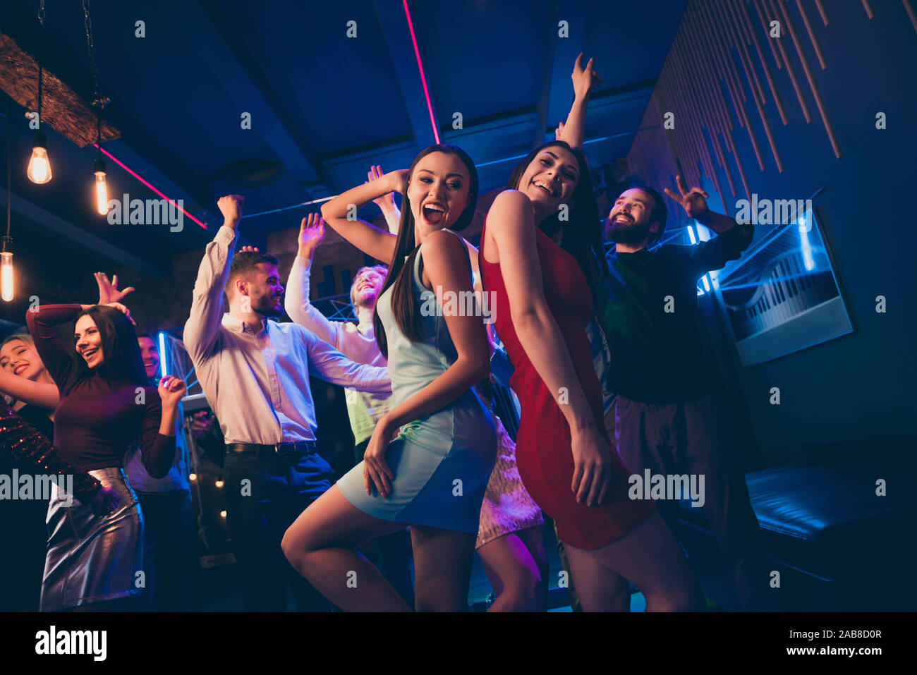 Lets party. Low angle view photo of cheerful wild crowd people dance on disco floor celebrate high-school graduation feel rejoice raise hands wearing Stock Photo