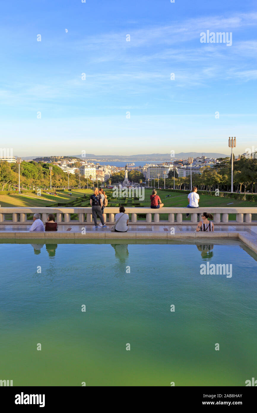 Tourists admiring the view down Eduardo VII Park, Parque Eduardo VII towards Marquês de Pombal and the distant Tagus River, Lisbon, Portugal. Stock Photo