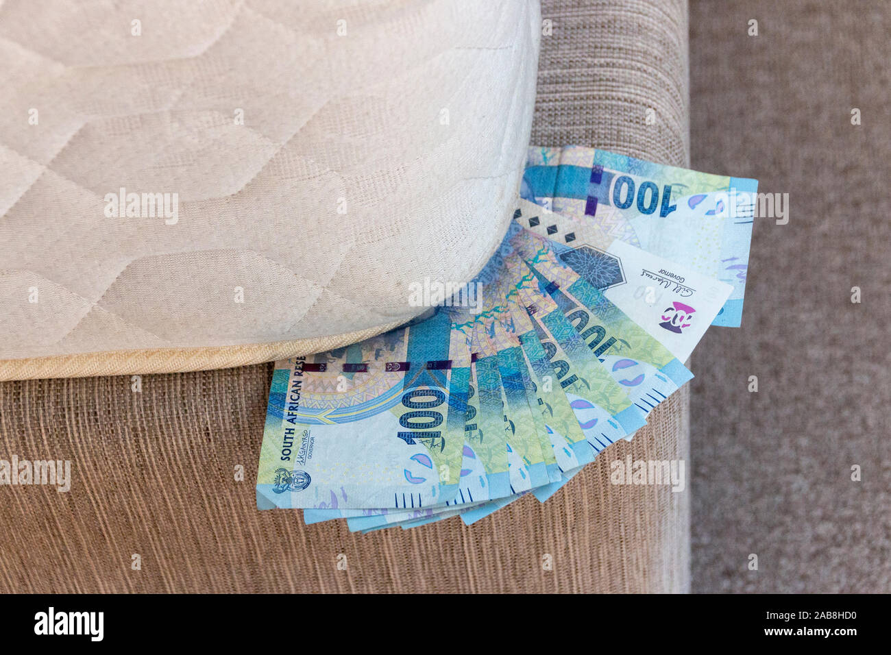 A close up view of one hundred rand note stikcing out of the conner of ...