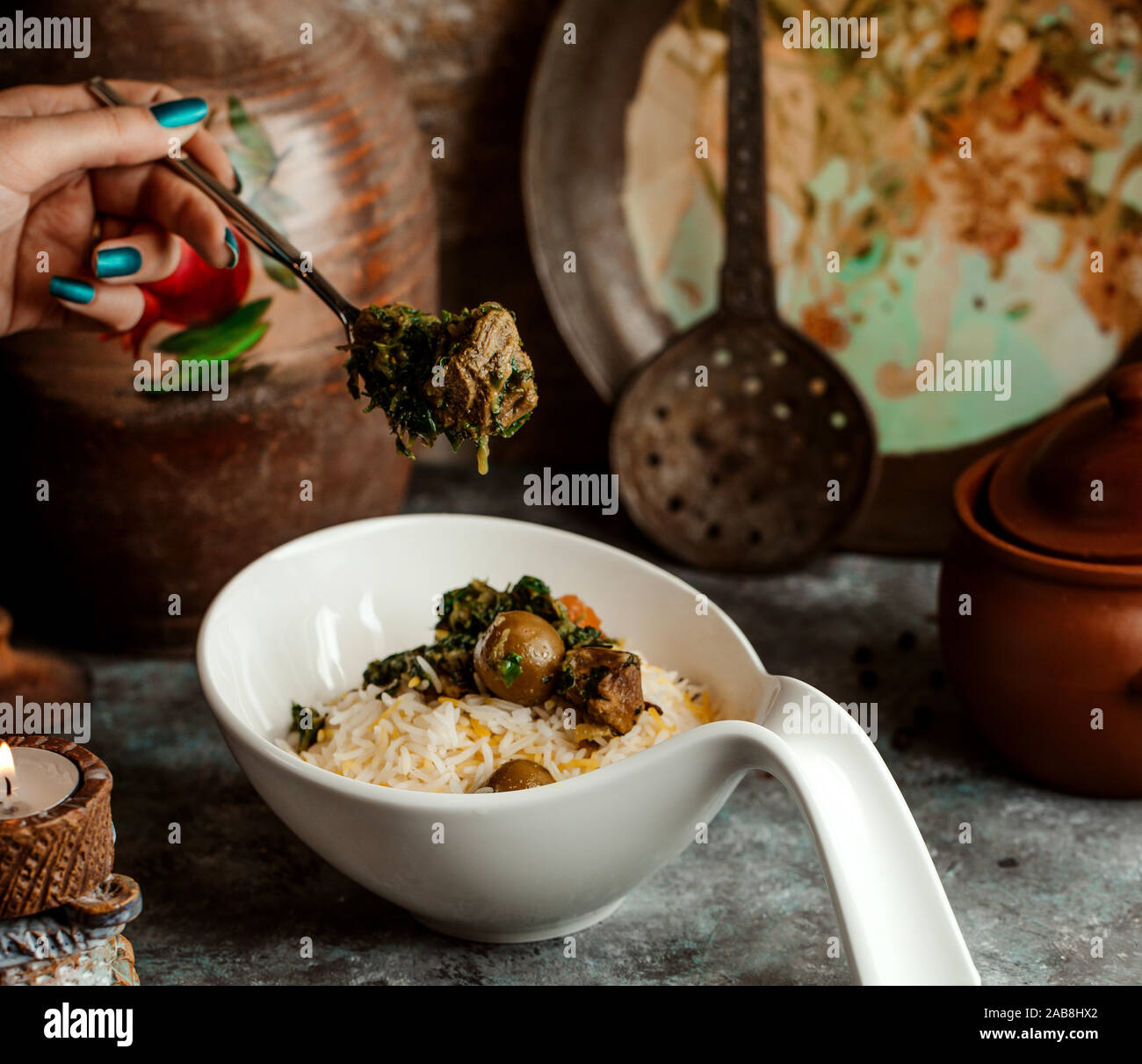 woman eating azerbaijani pilaf rice served with sabzi govurma Stock
