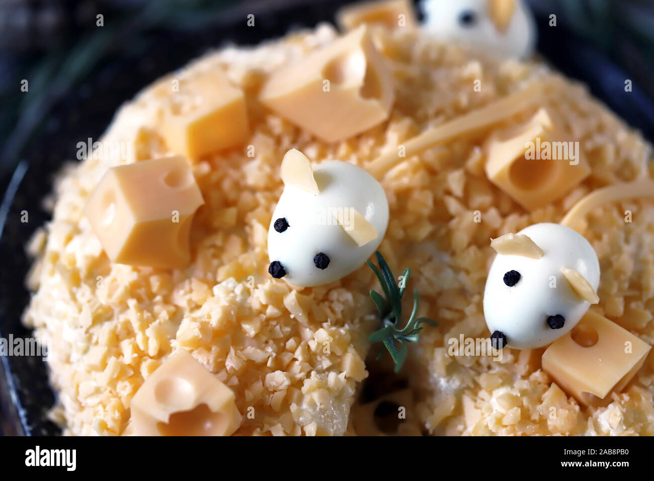 New Year 2020 salad. Mouse salad in cheese with pineapple and cheese. Decorations in the form of egg mice. Stock Photo