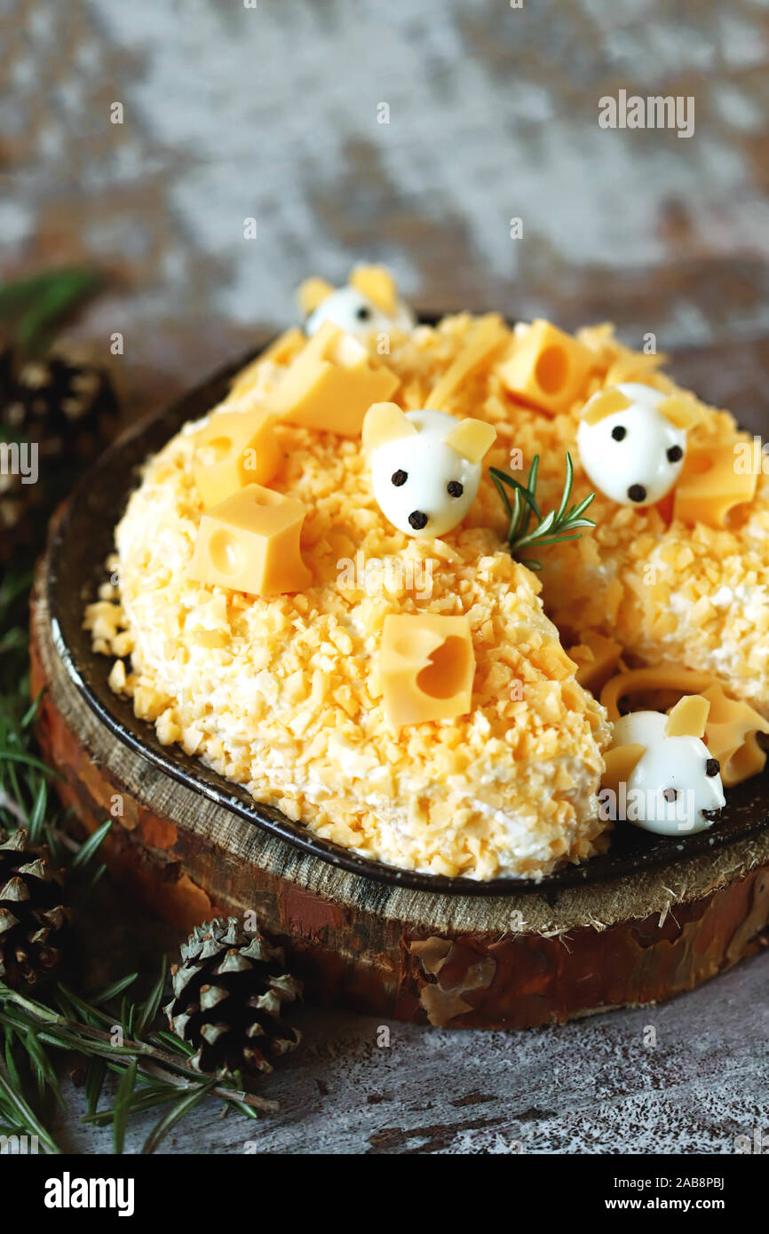 New Year 2020 salad. Mouse salad in cheese with pineapple and cheese. Decorations in the form of egg mice. Stock Photo