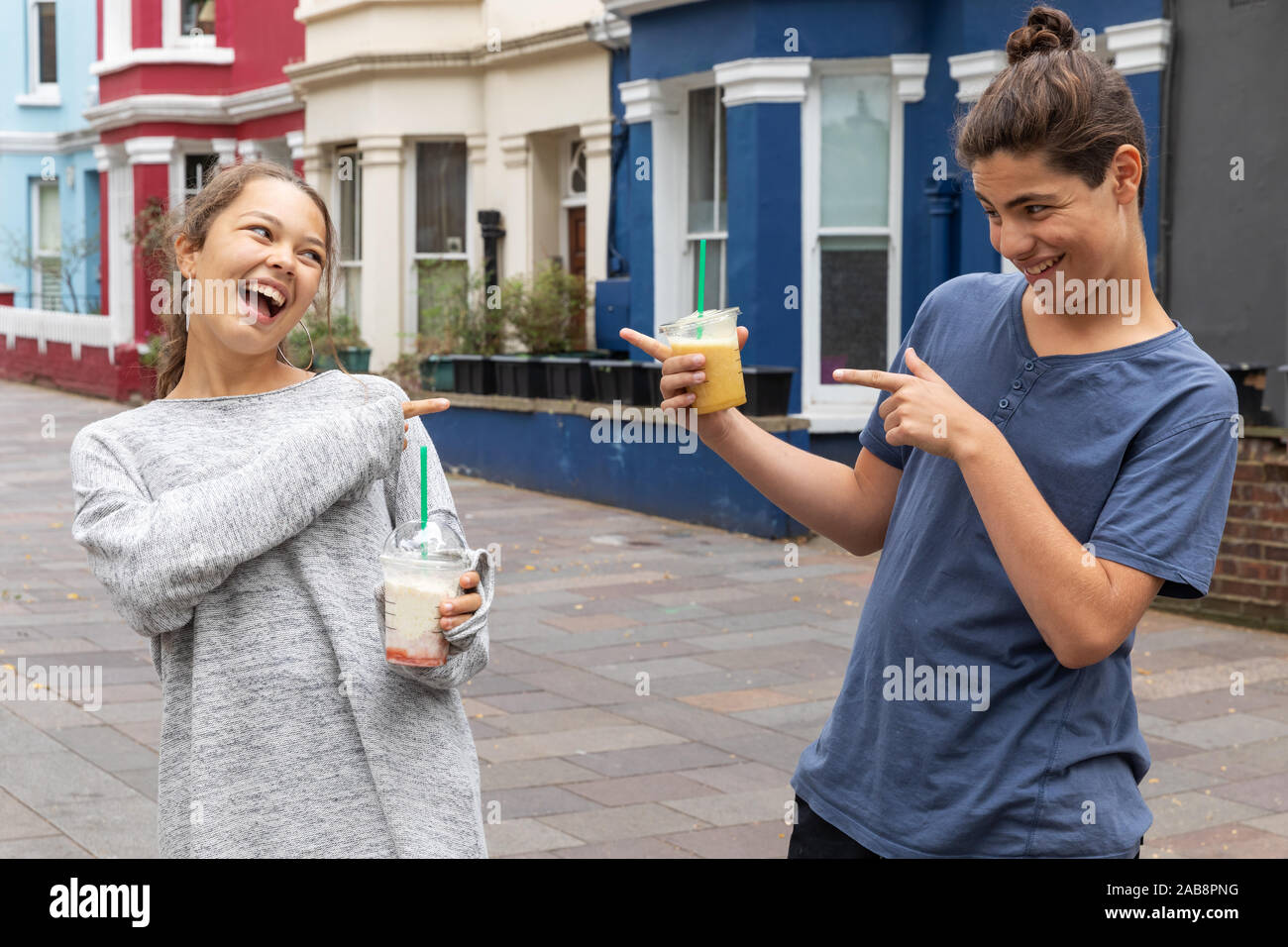 Teenager couple with shake in hand, fun and complicity. Urban context. Stock Photo