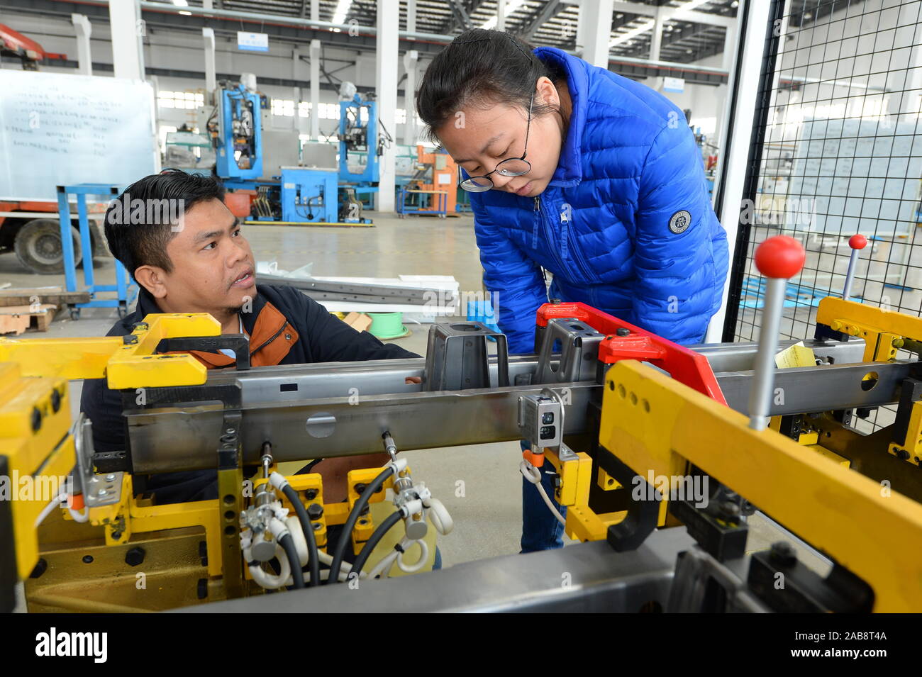 Chinese and Malaysian technicians check an auto parts assembly line to be exported to Malaysia