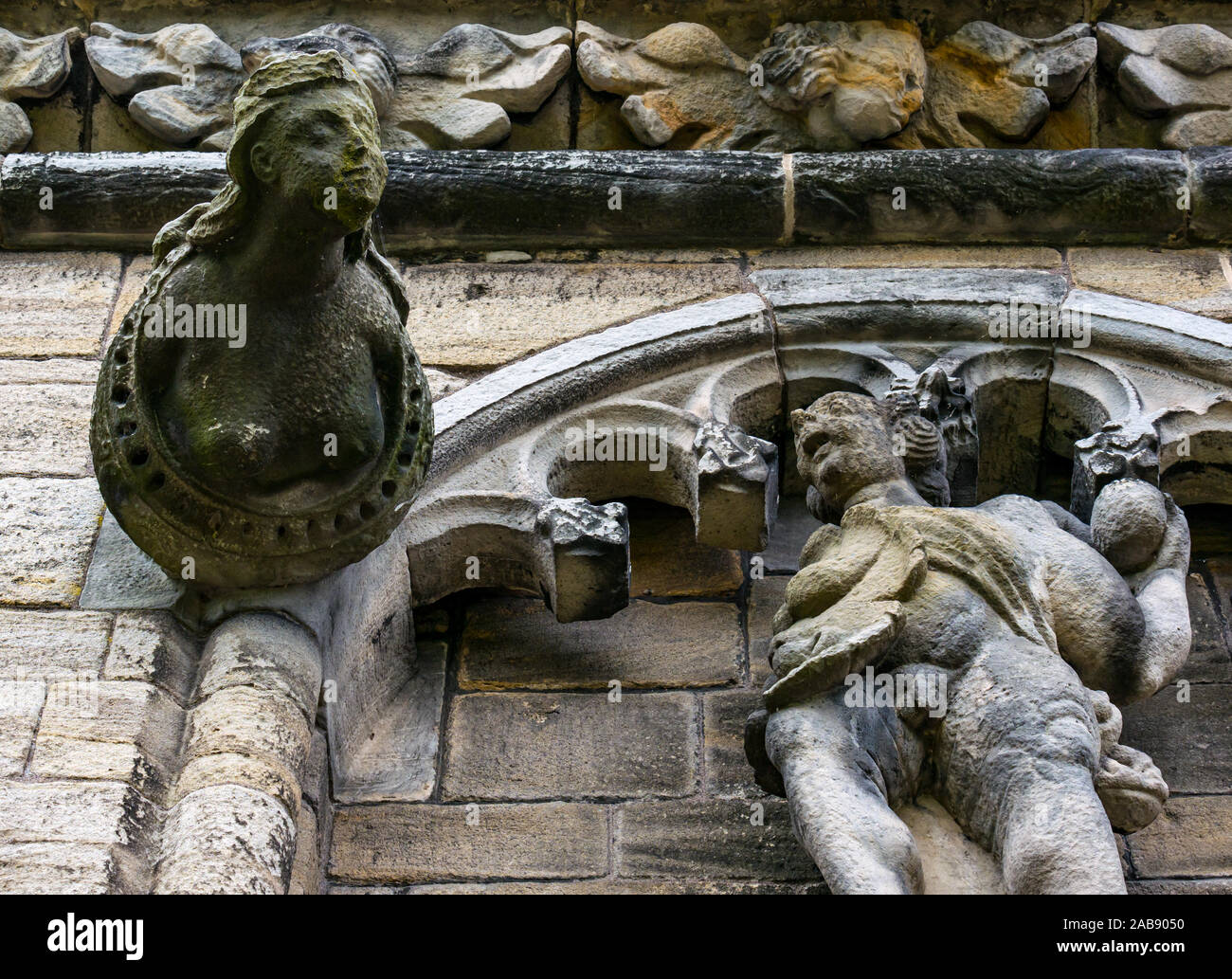Worn away old stone carved gargoyles of female bust and male with genitals showing on Stirling palace building, Stirling Castle, Scotland, UK Stock Photo