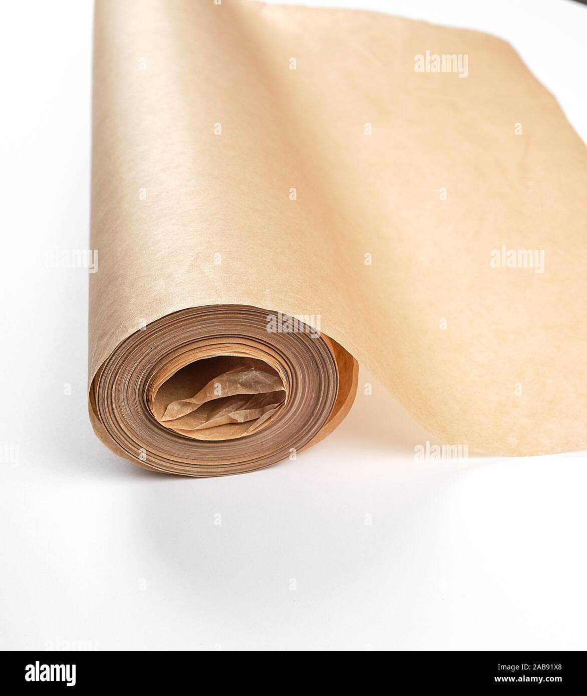 rolled brown parchment paper roll for baking on a white background