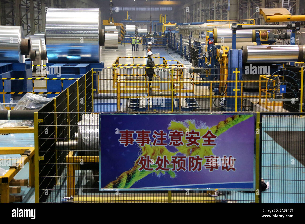 Chinese workers watch the production of coiled aluminium sheet at the plant of Zouping Hongfa Aluminium Technology Co., Ltd. in Zouping City, east Chi Stock Photo