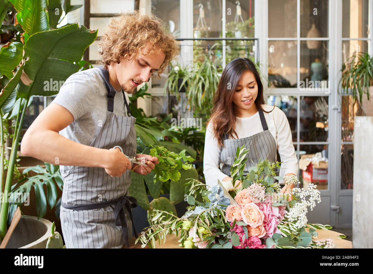 Florist team tying flowers for a bunch of flowers in the store Stock ...