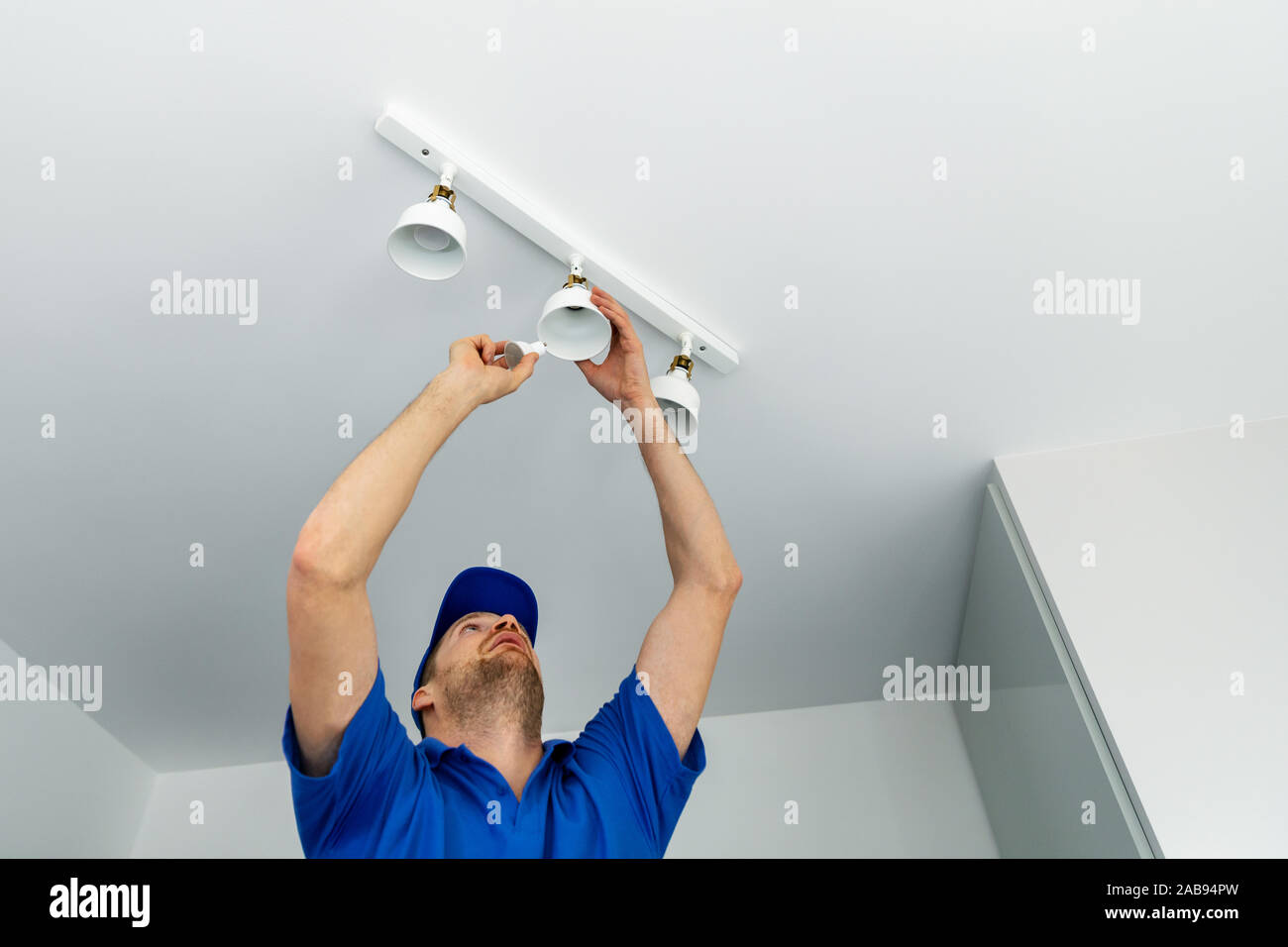 Electrician Installing Led Light Bulbs In Ceiling Lamp Stock Photo
