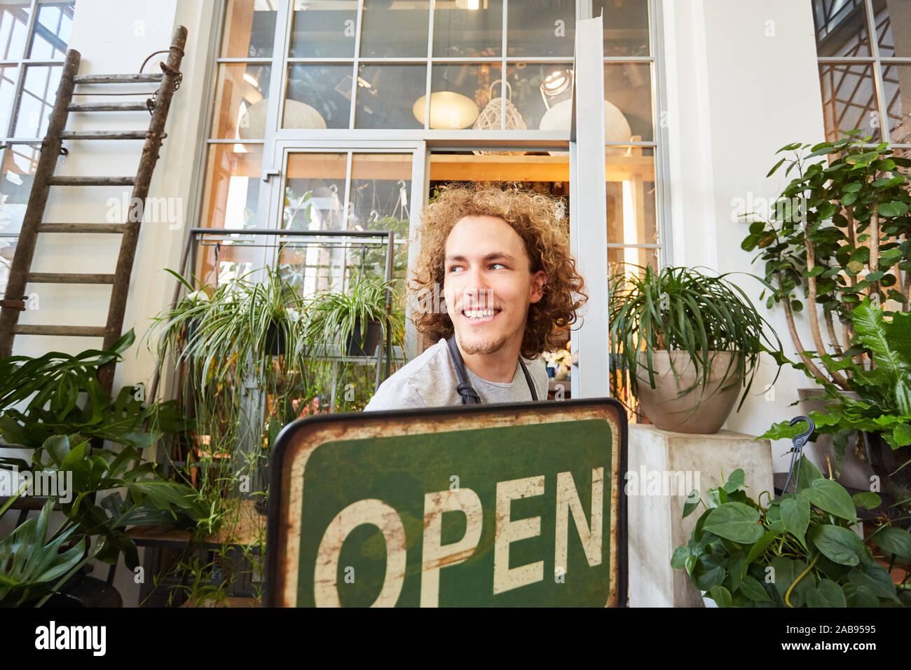 Florist with open sign at the opening of flower shop as a business Stock Photo