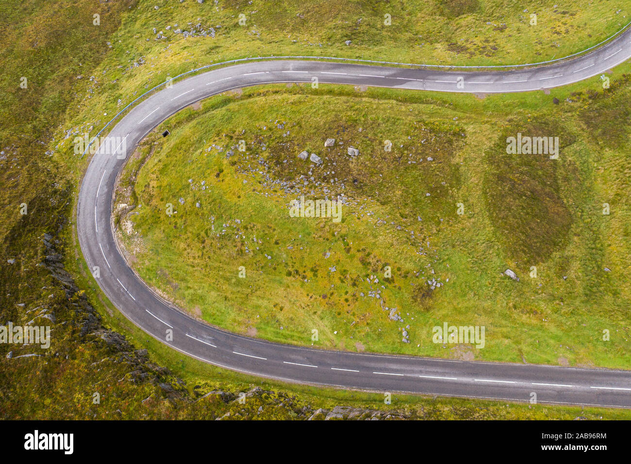 Drone top down shoot over curvy asphalt road A894 near the Quinag Mountain in the North West Highlands of Scotland - NC500 Route Stock Photo